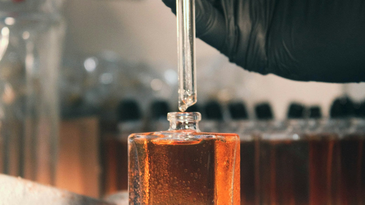 Pipeta dávkující parfémovou směs do flakonu v parfumérské laboratoři