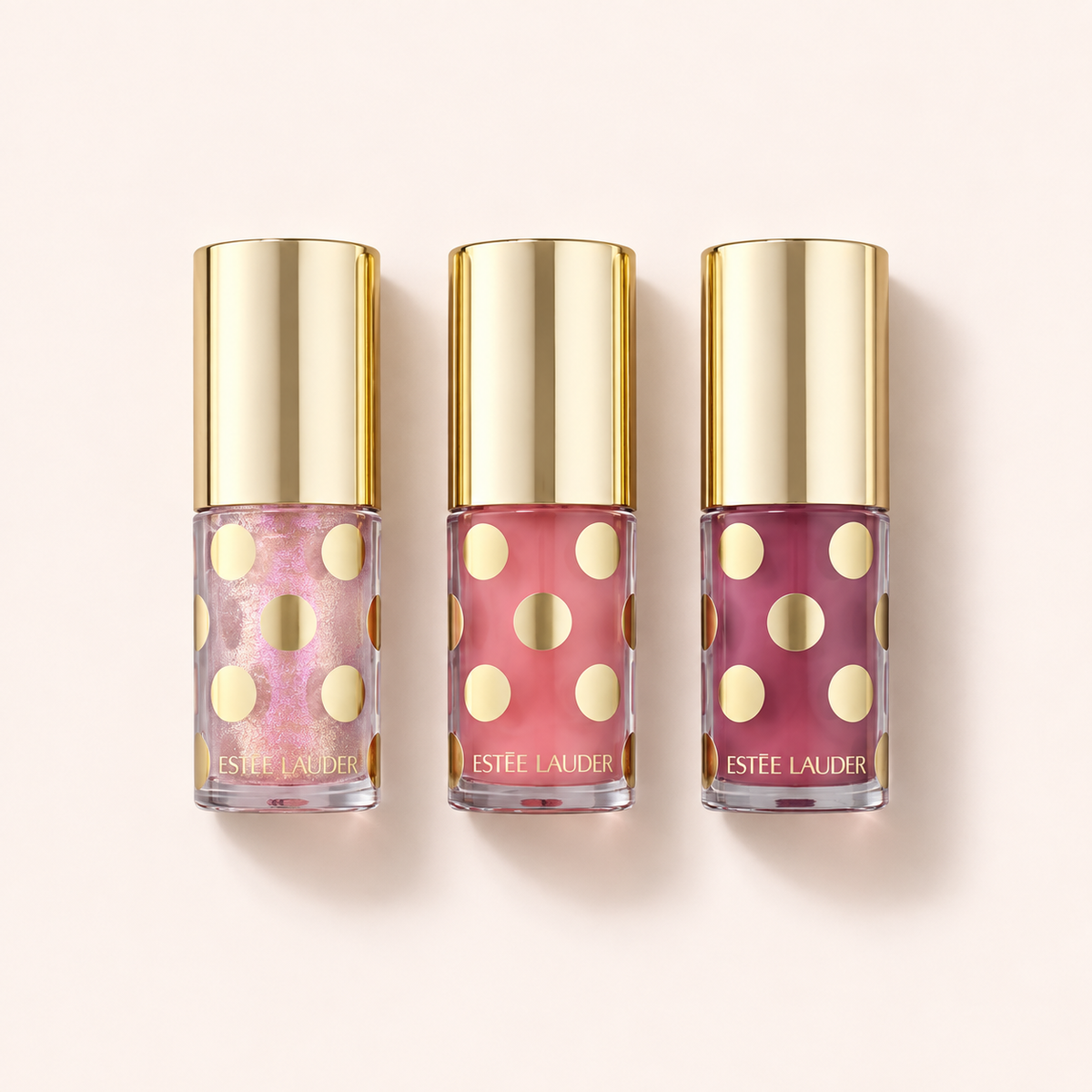 Tři oleje na rty Estée Lauder Sheer Wonders Limited Edition Lip Oil Trio po 4,5 ml na béžovém pozadí – MrRizz