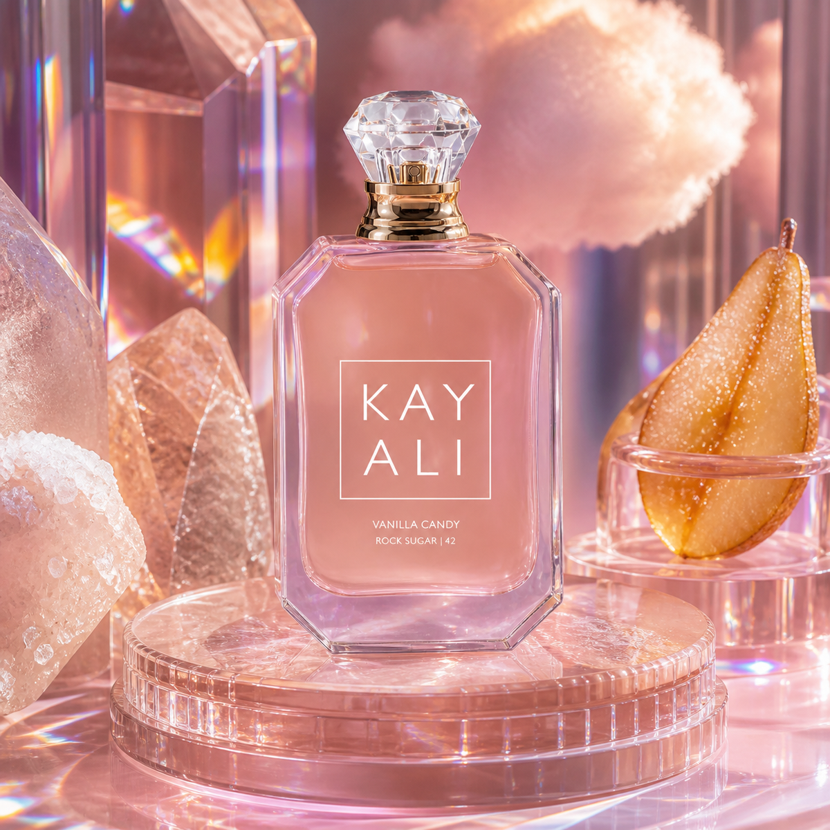 Kayali Vanilla Candy Rock Sugar 42 v růžovém skleněném zátiší s cukrovými krystaly a hruškou – MrRizz